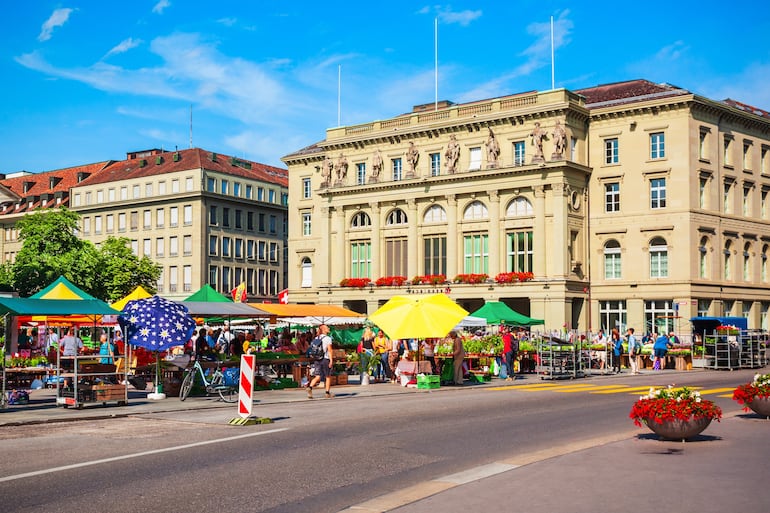 Mercado local de agricultores cerca del edificio del banco Kantonalbankgebaude en la plaza Bundesplatz en la ciudad de Berna en Suiza.