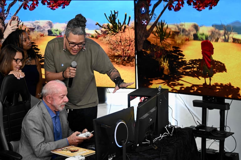 Brazil's President and presidential candidate Luiz Inacio Lula da Silva (2nd L), accompanied by First Lady Rosangela "Janja" da Silva (L), plays a video game before the signing ceremony for the decree regulating the Legal Framework for the Electronic Games Industry at the Planalto Palace in Brasilia on October 14, 2026. (Photo by Evaristo Sa / AFP)