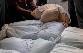 Una persona llora sobre los cuerpos de familiares fallecidos luego de un bombardeo israelí, este miércoles en el hospital Najar de Rafah, en el sur de la Franja de Gaza.