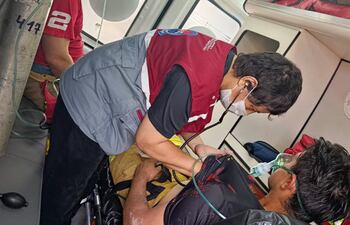 Dos bomberos voluntarios son atendidos por personal médico dentro de una ambulancia.