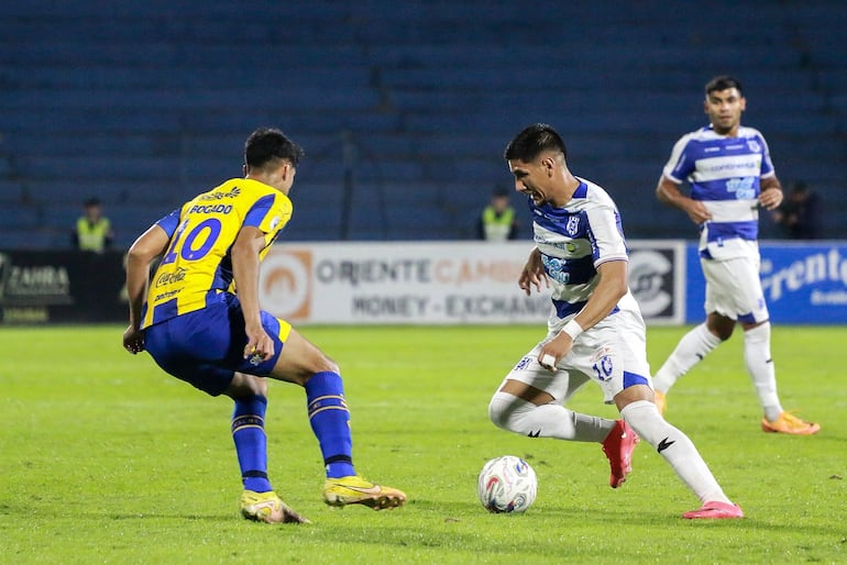El partido fue emotivo de principio a fin en Pedro Juan Cabalero. Los "10" Giovanni Bogado (izquierda) y Alan Gómez, disputan en balón ante la atenta mirada de Marcos Gómez.