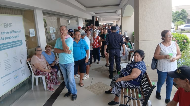 Adultos mayores soportan largas filas y calor extremo para cobrar pensión en BNF de San Lorenzo.