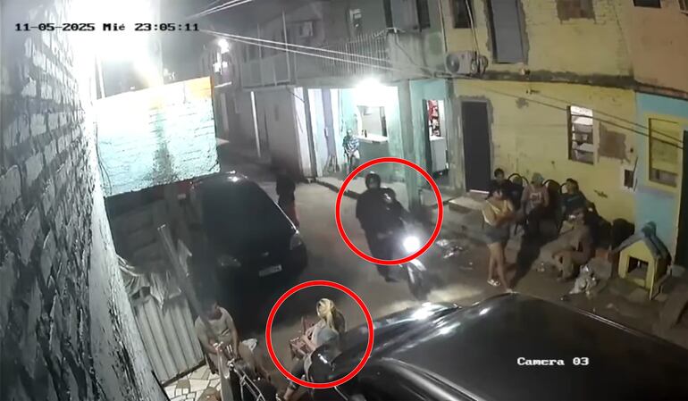 Los sicarios llegan en una moto y observan a su objetivo, quien estaba sentada con familiares y vecinos.