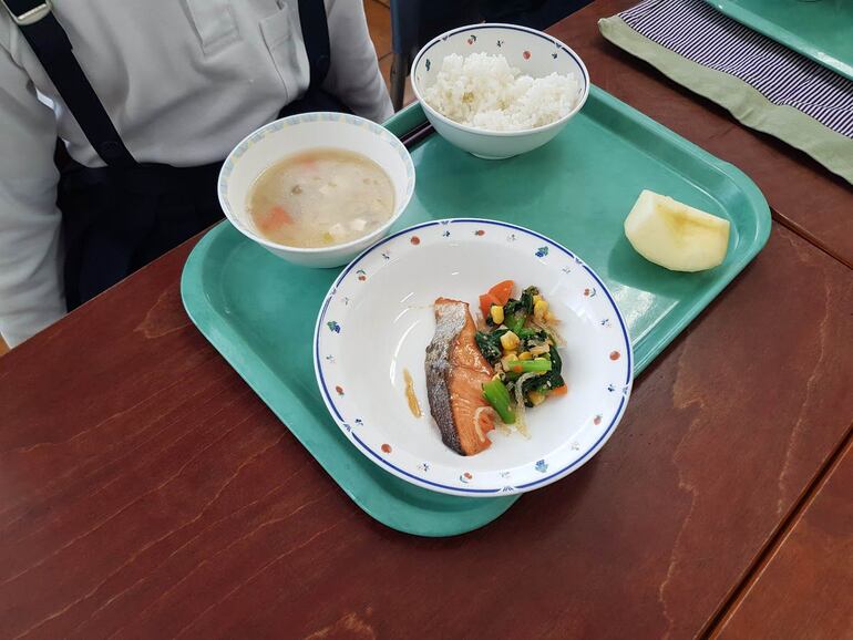 Sopa (en este caso miso), arroz y proteína (salmón con verduras variadas) y una porción de fruta son parte de un almuerzo escolar japonés. A esto se suma leche.