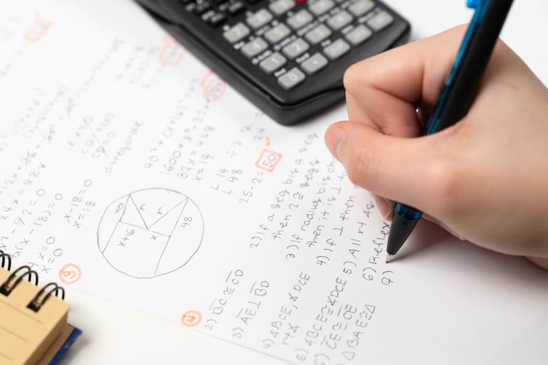 Una persona resolviendo ejercicios de matemática.