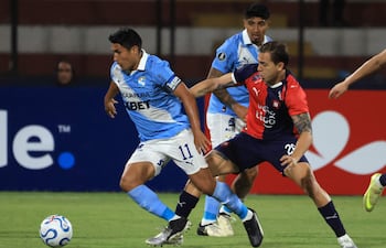 El delantero de Sporting Cristal, Irven Ávila (#11), y el defensa de Cerro Porteño, Gustavo Velázquez (#23), luchan por el balón durante el partido de fútbol de la fase de grupos de la Copa Libertadores entre Sporting Cristal de Perú y Cerro Porteño de Paraguay.