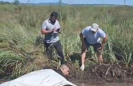 Momento en que algunos vecinos y conductores que circulaban por el lugar tratan de auxiliar al chofer del camioncito que fue a parar en un profundo canal lleno de agua