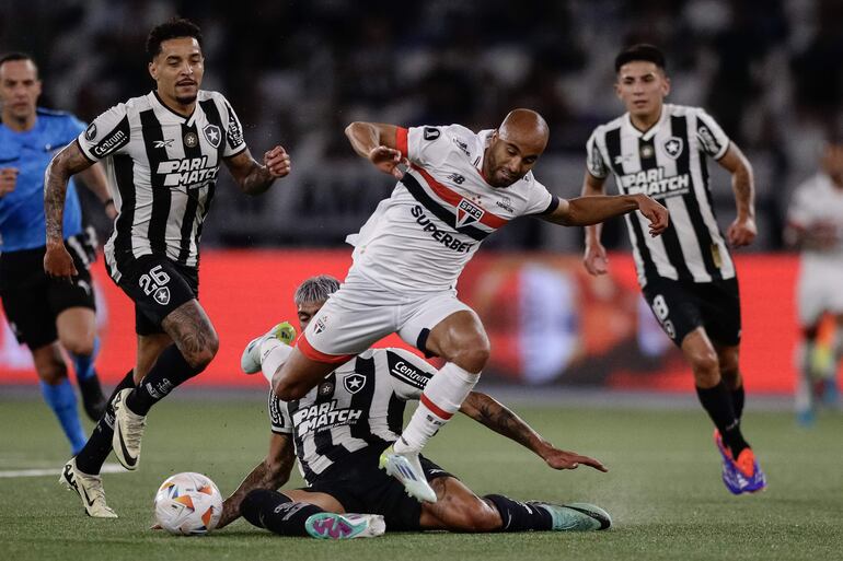 Alexander Barboza (abajo) de Botafogo disputa un balón con Lucas Moura (c) de Sao Paulo este miércoles, en el partido de ida de cuartos de final de la Copa Libertadores entre Botafogo y Sao Paulo en el estadio Olímpico Nilton Santos en Río de Janeiro (Brasil).