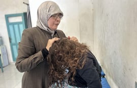 AL MAWASI (FRANJA DE GAZA), 06/10/2026.- La terapeuta Nawal Asqul (terapeuta) atiende a niños afectados por el trauma de la guerra en Al Mawasi (Franja de Gaza). Siwar tiene ocho años y hasta hace tres salía sola a la calle, iba y venía del colegio y bajaba a jugar sin pedir permiso. Hoy no se atreve a ir al baño si su madre no la acompaña. Su padre murió el 5 de diciembre de 2023, dos meses después de que estallara la guerra, y desde entonces la niña engordó de golpe y vive pegada a ella. Tres años después de la ofensiva israelí en Gaza, los niños gazatíes afrontan graves secuelas psicológicas: pesadillas, incontinencia, tartamudez, agresividad e hiperactividad son algunos de los síntomas detectados por terapeutas, mientras miles de menores han perdido a uno o ambos progenitores. EFE/