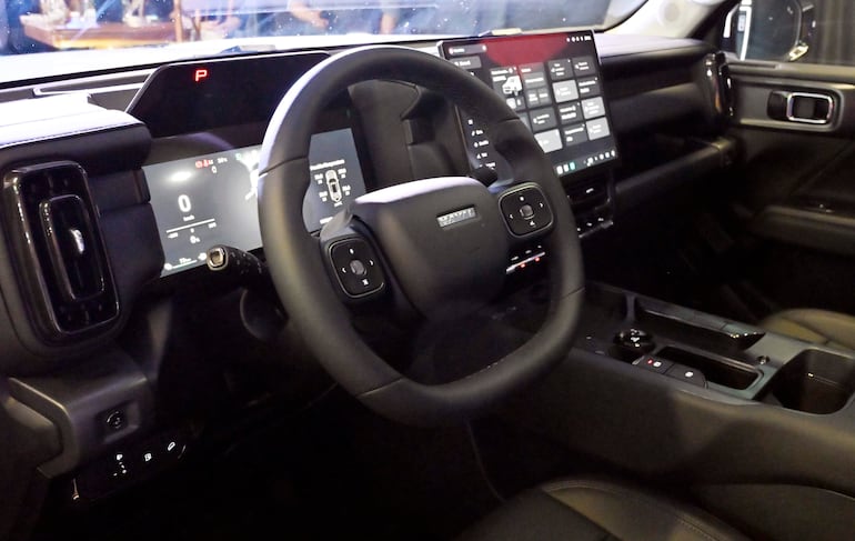 Interior de un vehículo moderno con volante y tablero digital, sin personas visibles.