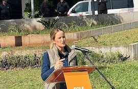 Soledad Núñez en podio, gesticulando mientras pronuncia su discurso, rodeada de asistentes en un evento al aire libre.