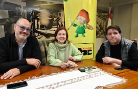 Luis María Peña con barba y gafas sonríe, mientras Stael Ruffinelli sostiene un objeto. Sergio Cuquejo observa atentamente.