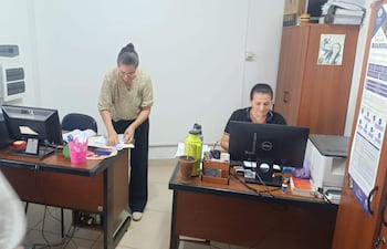 Momento en que la abogada Sinthia Ruiz (izquierda) presenta la carpeta de denuncia en el despacho del fiscal José Godoy, en Santa Rosa del Aguaray.