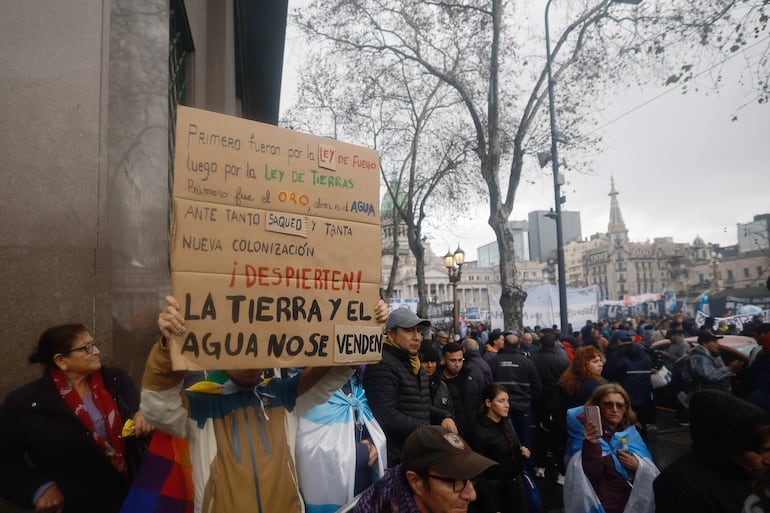 Una persona sostiene un cartel en una manifestación contra un proyecto de ley impulsado por el Gobierno del ultraliberal Javier Milei que introduce cambios en los procesos de desalojo, expropiaciones y uso de tierras quemadas, este jueves en Buenos Aires