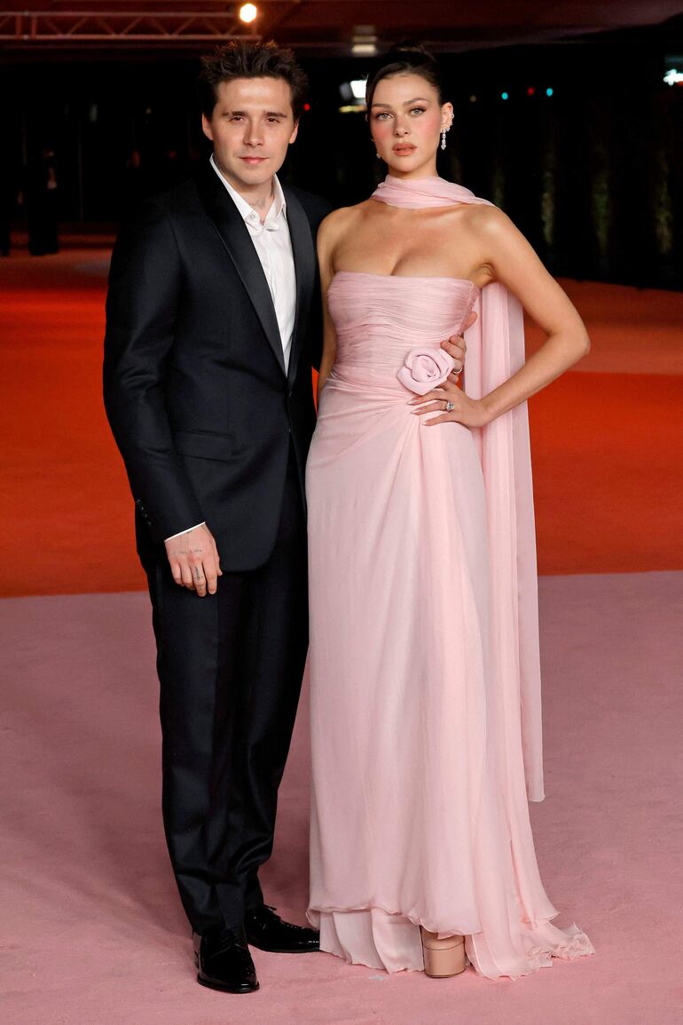 Brooklyn Beckham y su esposa Nicola Peltz, quien optó por un maxivestido rosa para asistir a la Gala del Museo de la Academia en Los Ángeles. (Frazer Harrison/Getty Images/AFP)