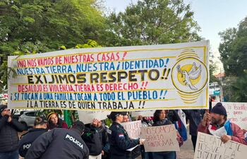 Grupo de manifestantes en Asunción sosteniendo pancartas con mensajes de protesta sobre desalojo y derechos sociales.