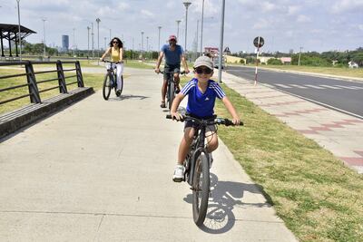 Una familia pasea en bicicleta por la Costanera de Asunción, ahora que el aire recuperó su calidad, según el Mades.