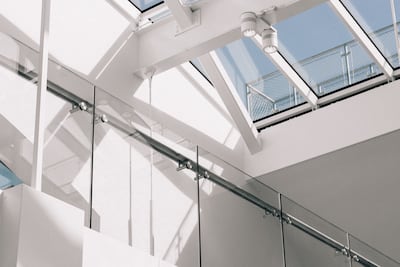 Interior de un edificio moderno, con paredes blancas y una vista al cielo.