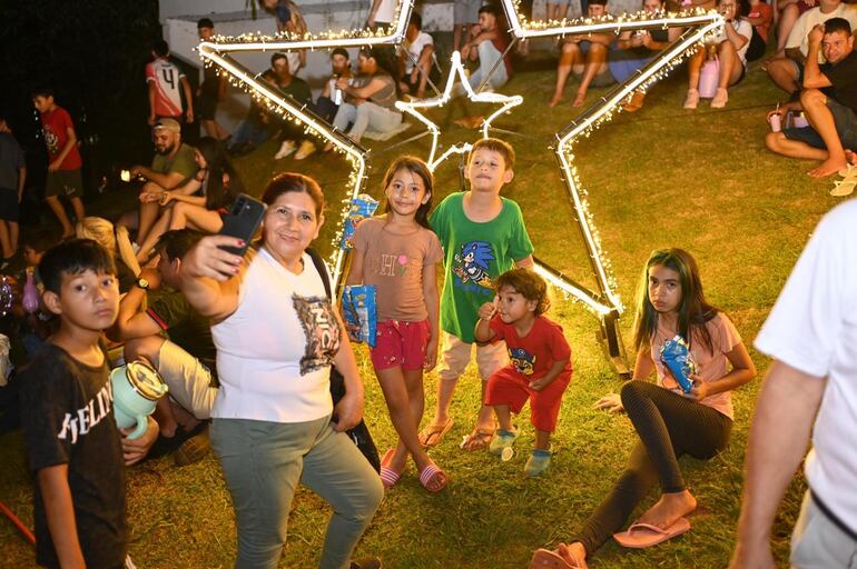 Una familia se fotografía frente a uno de los decorativos navideños en el lago de la República.