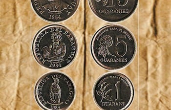 Monedas de 1, 5 y 10 guaraníes sobre fondo arrugado, con inscripciones que mencionan 'Alimentos para el mundo'.