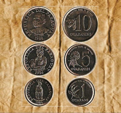 Monedas de 1, 5 y 10 guaraníes sobre fondo arrugado, con inscripciones que mencionan 'Alimentos para el mundo'.
