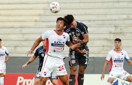 El zaguero del Sportivo San Lorenzo, Alexis Doldán se impone en el duelo aéreo ante el experimentado atacante Roque Santa Cruz, en el duelo por la primera fecha del torneo Apertura 2026, disputado en el Arsenio Erico.