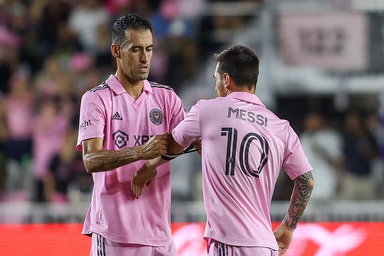 Lionel Messi (d), futbolista del Inter Miami, recibe el brazalete de capitán de Sergio Busquets en el partido ante Cincinnati por la Major League Soccer. 