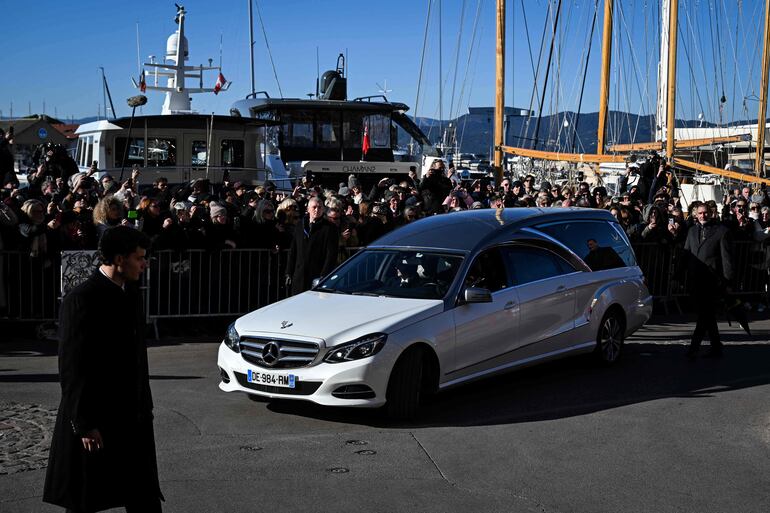El coche fúnebre que transporta el ataúd pasa junto a los fanáticos y los dolientes hacia el cementerio marino, luego de la ceremonia fúnebre de la fallecida actriz francesa Brigitte Bardot en la iglesia de Notre-Dame de l'Assomption, en Saint-Tropez, sureste de Francia. (Miguel MEDINA / AFP)