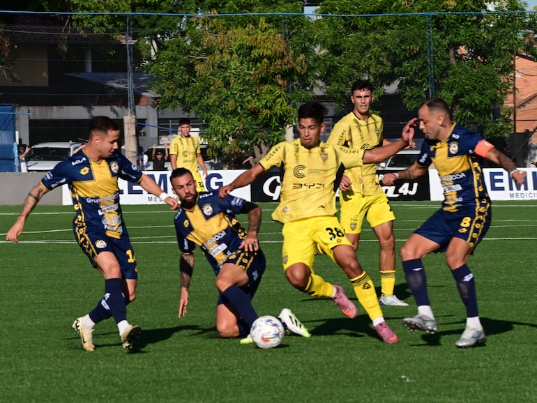 Los futbolistas de Recoleta FC (amarillo) y Sportivo Trinidense disputan el balón en un partido por la primera fecha del torneo Apertura 2026 de la Primera División de Paraguay en el estadio Ricardo Gregor, en Asunción, Paraguay.