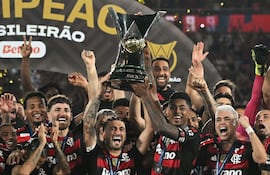 Giorgian de Arrascaeta y Bruno Henrique, principales referentes del Flamengo, sostienen el trofeo de campeón conquistado por el club más popular del Brasil.