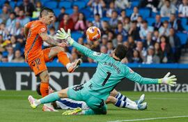 El delantero del Celta Alfon González (i) marca ante el portero Álex Remiro, de la Real, durante el partido de la jornada 36 de LaLiga EA Sports que Real Sociedad y Celta de Vigo disputan este martes en el estadio Reale Arena, en San Sebastián.