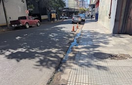 Calle urbana en Asunción con camioneta roja y conos de tránsito, sin personas visibles.