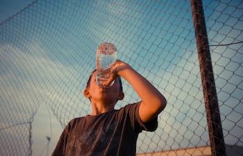 Niño tomando agua, golpe de calor, deshidratación.