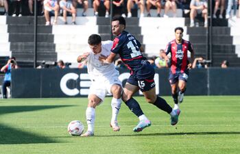 Duelo de laterales, Iván Ramírez, de Libertad intenta escapar de la marca de Blas Riveros, de Cerro Porteño.