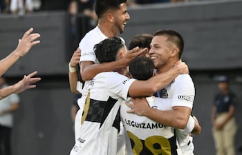 El volante Hugo Quintana recibe las felicitaciones de sus compañeros tras anotar el segundo gol de Olimpia, en la victoria frente al Sportivo Trinidense.