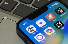 En la pantalla de un iPhone se observan diversas aplicaciones de IA, incluidas ChatGPT, Gemini, Claude, Perplexity, Meta AI, Microsoft Copilot y Grok.