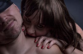 Una mujer muerde a su pareja en el cuello.