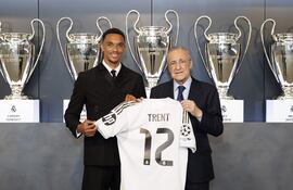 El futbolista inglés Trent Alexander-Arnold (i) posa con la camiseta con el dorsal 12 que lucirá como nuevo jugador del Real Madrid, acompañado del presidente del club, Florentino Pérez, este jueves durante su presentación.