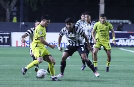 El joven extremo de Recoleta FC, Juan José Falcón intenta encarar la marca del zaguero de Libertad, Robert Rojas. (Foto: APF)
