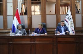 Diego Crispín Candia Melgarejo habla con documentos en mano, mientras Alicia Pucheta sonríe y escucha atenta, en ambiente institucional.