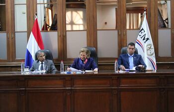 Diego Crispín Candia Melgarejo habla con documentos en mano, mientras Alicia Pucheta sonríe y escucha atenta, en ambiente institucional.