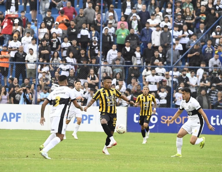 El extremo ecuatoriano de Guaraní, Jhon Jairo Sánchez domina el esférico en medio de las marcad de Héctor David Martínez y Alex Franco.