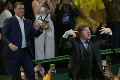 El presidente de Argentina, Javier Milei, hace un gesto junto al candidato presidencial de derecha de Brasil, Flavio Bolsonaro, durante el lanzamiento de la candidatura de este último en la convención del Partido Liberal, en São Paulo, Brasil