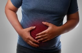 Un hombre con sobrepeso se agarra el estómago.