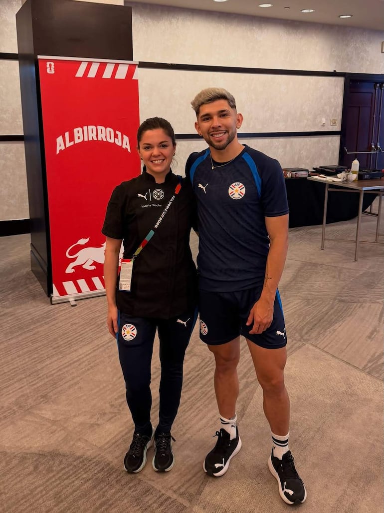 Ramón Sosa sonríe con camiseta azul, junto a Valeria Troche en camisa negra, ambos en un ambiente de celebración.
