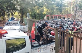Los agentes bajan una de las motocicletas incautada de la patrullera policial.