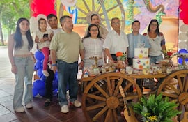 Benito Ulpiano Salinas junto a un pastel decorado con el número 100, rodeado de su familia.