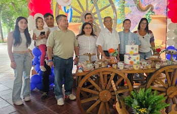 Benito Ulpiano Salinas junto a un pastel decorado con el número 100, rodeado de su familia.