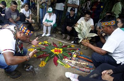 Jaibaná o médico tradicional, José Arnulfo Vaguiaza (i) junto a otro Jaibaná, miembros de la comunidad Embera Chamí, realizando un ritual de limpieza espiritual en el resguardo Karmata Rúa durante la ruta de turismo étnico en el municipio de Jardín, Antioquia (Colombia).