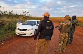 Agentes de la Senad observan el automóvil en el que quedaron los cuerpos de ambos abatidos y las armas que portaban. Fue el viernes pasado, Corpus Christi, Canindeyú y la Senad asegura que los fallecidos tenían vínculos con el prófugo Felipe Santiago Acosta Riveros, alias Macho.